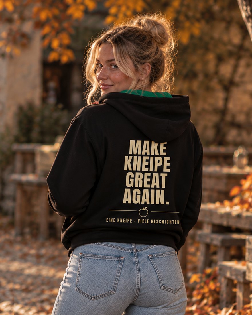 Eine Frau trägt den schwarzen Kapuzenpullover, auf dem Rücken steht Make Kneipe great again, eine Kneipe, viele Geschichten