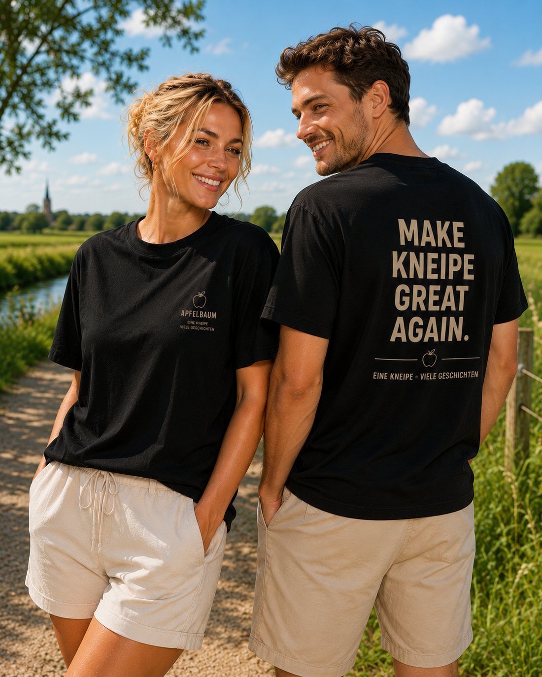 Ein Paar trägt die schwarzen Apfelbaum-Shirts, vorne mit Apfel-Logo, hinten mit dem Spruch Make Kneipe great again